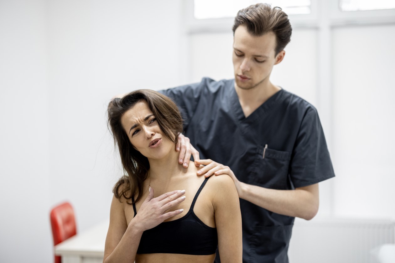 Fizjoterapeuta ocenia postawę pacjentki, ukazując znaczenie profesjonalnego wsparcia w doborze rozwiązań dla zdrowego kręgosłupa.